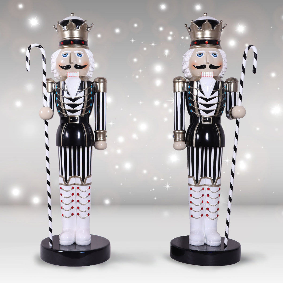 Pair of life-sized 6.5ft tall Nutcracker Kings in a classic black and white striped uniform, holding striped candy canes against a festive shimmering background.