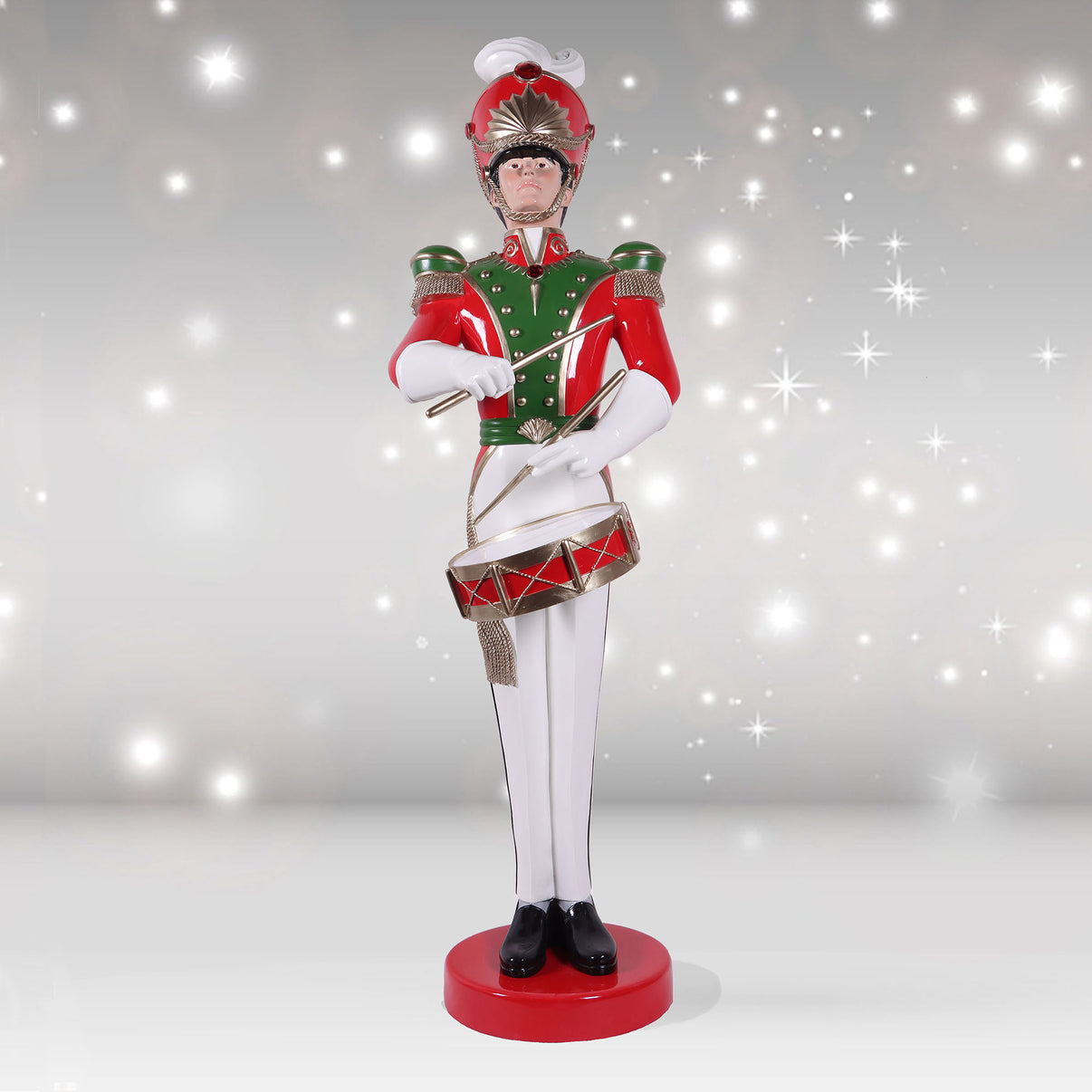 Decorative figure of a drummer in red and green uniform on a sparkling background
