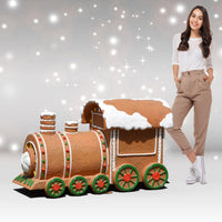 Person standing next to a large gingerbread train model on a starry background